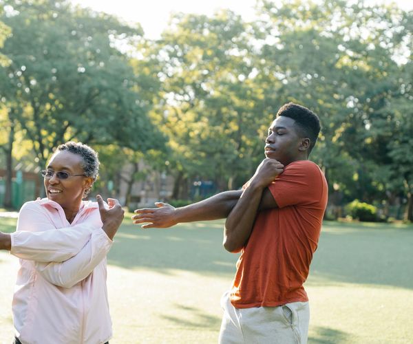 Woman stretching outdoors at sunrise, symbolizing renewed energy and vitality.